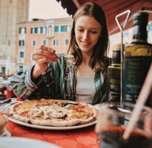 Touristin isst Pizza in Italien